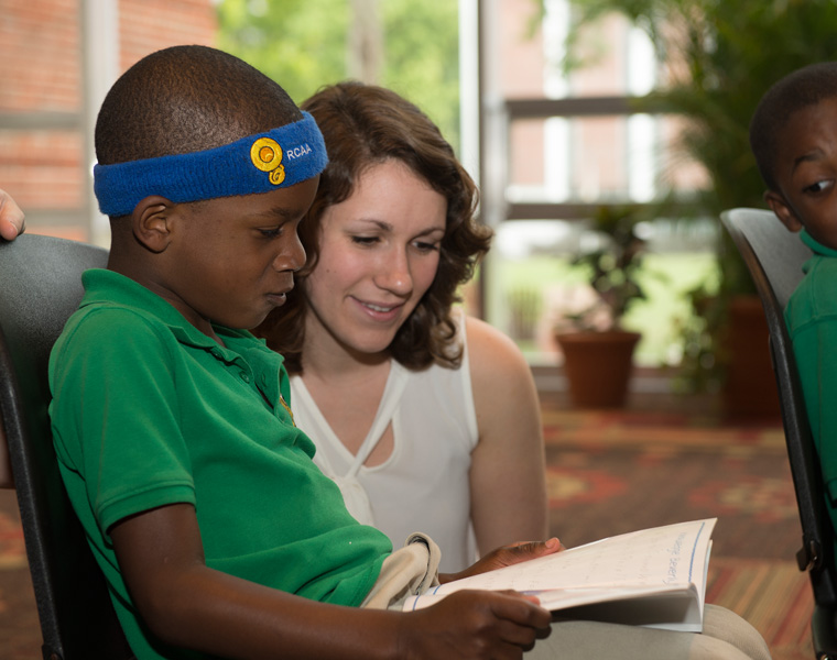 Primary teacher and student with book